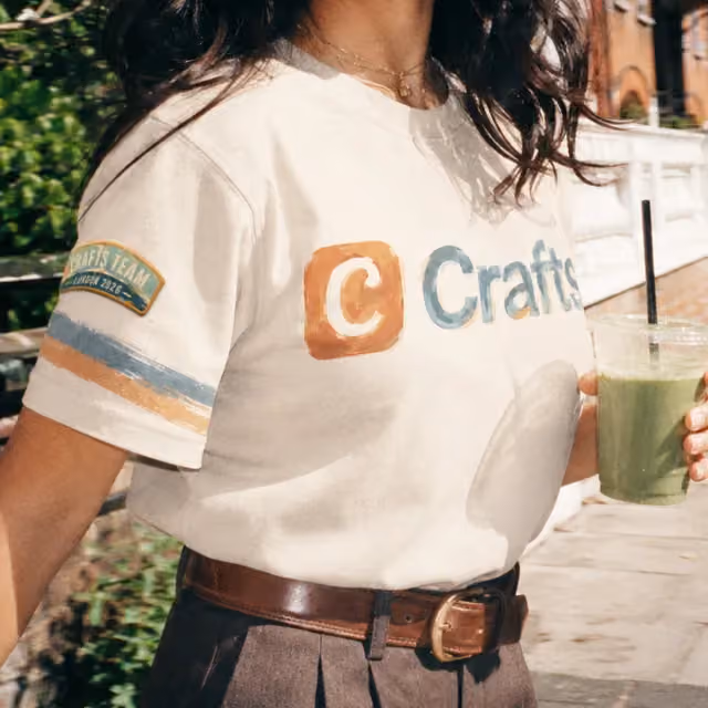 Cream tee with a chest logo, worn with a belt
